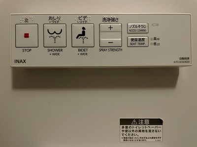 Bedienungsfeld einer japanischen Toilettenspülung mit zahlreichen Tasten, Symbolen, englischer Beschriftung und japanischen Schriftzeichen