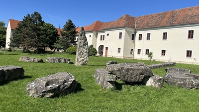 Ein Steinkreis mit Hinkelsteinen und Hauptmenhir in der Mitte aus der Jungsteinzeit vor Manufaktur Holitsch