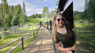 Helden der Freizeit Redakteurin Miriam lehnt sich aus dem Waggonfenster - im Hintergrund zieht die Dampflok die Waldviertelbahn