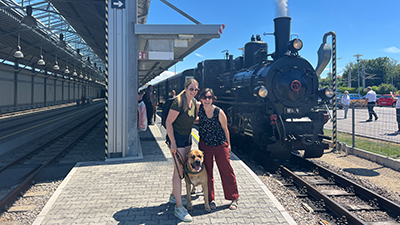 Zwei Frauen mit Hund vor der Dampflok der Waldviertelbahn am Bahnhof Gmünd