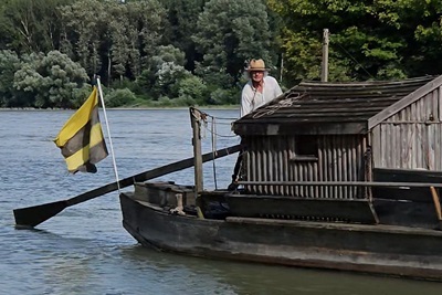 Martin Zöberl auf seiner Tschaike auf der Donau mit dem Ruder in der Hand.