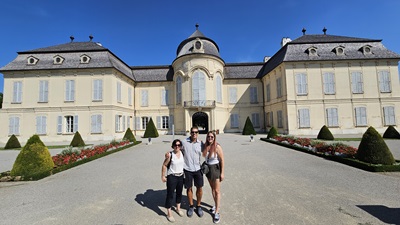 Ein Mann und zwei Frauen stehen vor dem Schloss Niederweiden