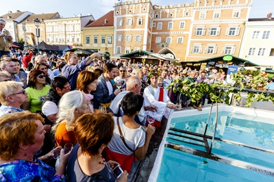 Menschenmenge am Retzer Hauptplatz vor dem Weinbrunnen aus dem beim Weinlesefest Wein fließt.