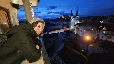 Frau blickt vom Rathausturm auf Brno hinunter