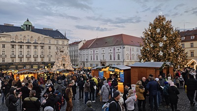 Viele Menschen am Zelný trh in Brünn - einem der Weihnachtsmärkte vor den Ständen, dem Weihtnachtsbaum und dem Parnass-Brunnen.