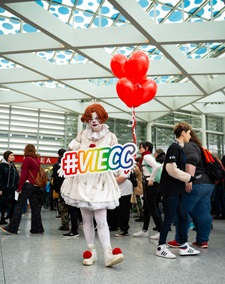 Ein Cosplayer als Clown von ES und mit #viecc Schild bei der Vienna Comic Con in Wien