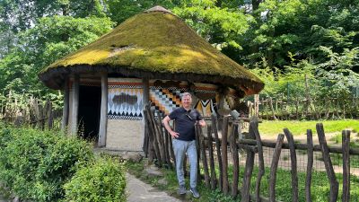 Eine runde Hütte des äthiopischen Konso-Volks im Zoo Zlín. Das Dach läuft in der Mitte spitz zu und ist stark bemoost. Davor ein einfacher Holzzaun.