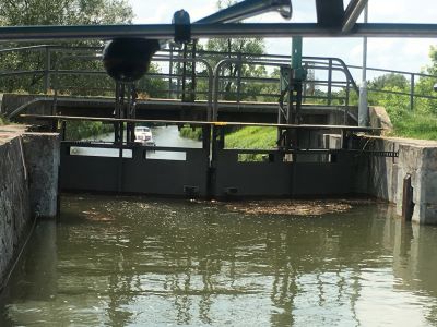 Blick auf ein geschlossenes Schleusentor im Bata-Kanal aus einer voll mit Wasser gefüllten Schleusenkammer.