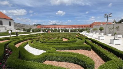 Immergrüne, auf einen halben Meter Höhe in barocken Formen geschnittene Buchsbaumhecken eines Gartenparterres, eingerahmt von niedrigen barocken Nebengebäuden der Preßburger Burg.