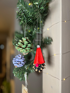 Bockerl-Christbaumschmuck selbst gestaltet hängend an einem Tannenzweig