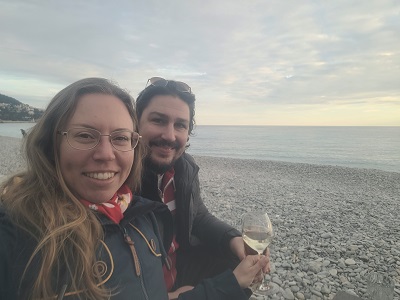 Sabrina und Daniel stoßen am Strand von Nizza auf den Beginn ihres Städtetrips an