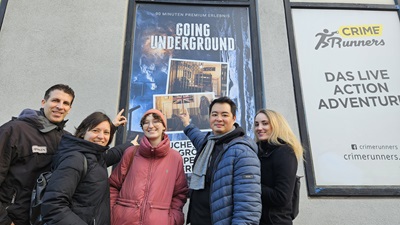 Die Helden der Freizeit Redakteur:innen vor dem Going Underground Plakat der Crime Runners auf der Wiener Alser Straße