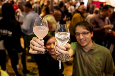 Pärchen hält beim Vienna Gin Festival zwei gefüllte Tasting-Gläser in die Kamera.