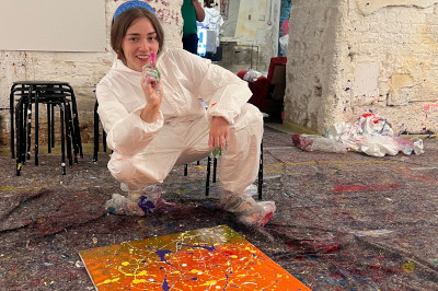 Frau mit Farbpistole beim Action painting diy Workshops